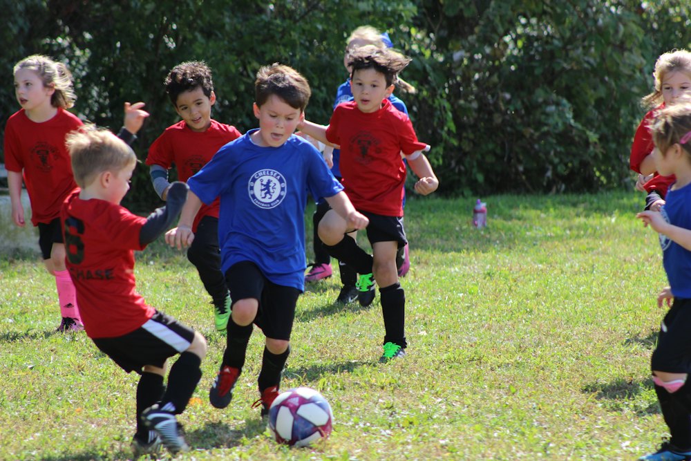Chicos de escuelita disputando la pelota en un partido